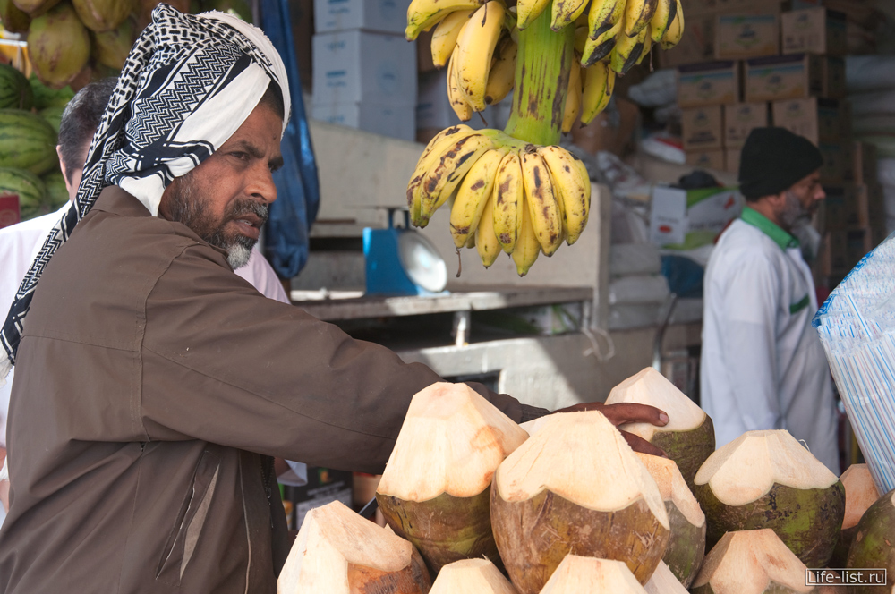 продавец кокосов на овощном рынке в дубае