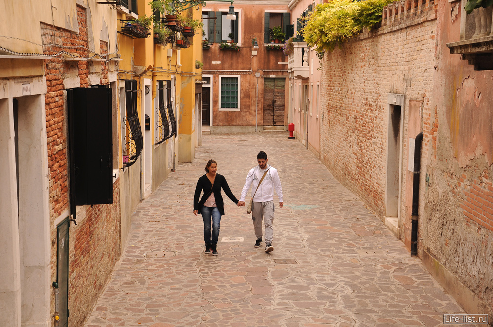 Молодая пара прогуливается по улицам Венеции Италия