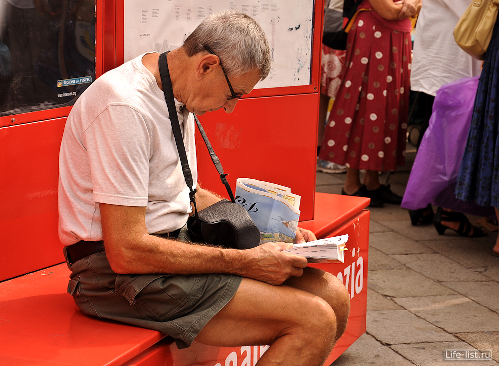 Турист читает путеводитель по Венеции